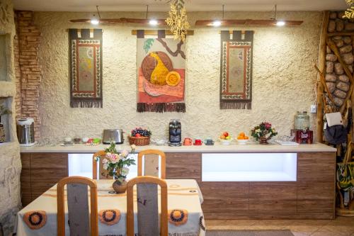 a kitchen with a counter with a table and chairs at Ethno boutique Hotel Osh in Osh