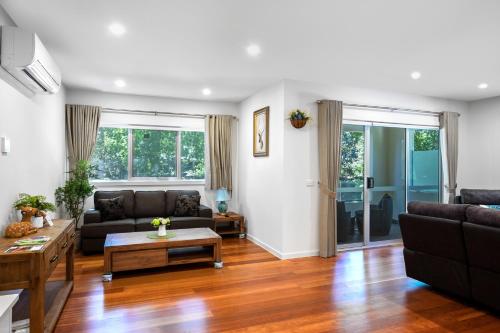 a living room with a couch and a table at Woody lifestyle one bedroom apartment in Olinda
