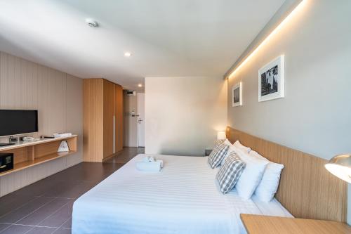 a hotel room with a bed and a television at Naga Residence in Bangkok