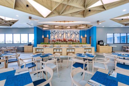 a restaurant with blue walls and tables and chairs at BlueSotel SMART Krabi Aonang Beach - Adults only in Ao Nang Beach