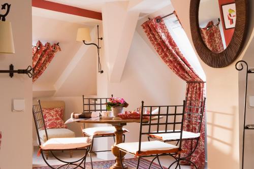 - une salle à manger avec une table, des chaises et un miroir dans l'établissement Hotel Le Central, à Trouville-sur-Mer