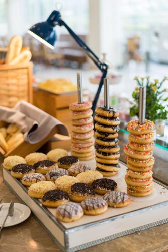 una mesa con una bandeja de galletas y donas en Le Eminence Puncak Hotel Convention & Resort, en Puncak
