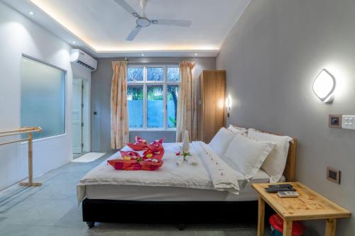 ein Schlafzimmer mit einem Bett mit Blumen darauf in der Unterkunft Koimala Beach Ukulhas in Ukulhas
