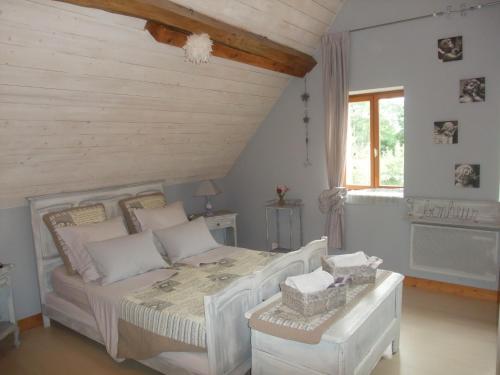 une chambre avec un lit blanc et une fenêtre dans l'établissement La Maison Du L.A.C., à Simard