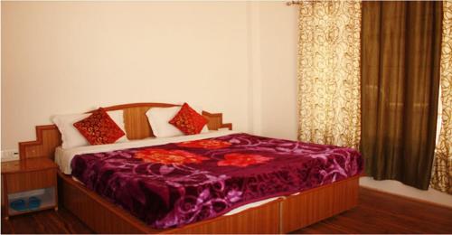 a bedroom with a bed with a purple comforter at Hotel Wang Residency in Leh
