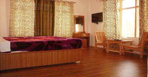 a bedroom with a bed and a table and chairs at Hotel Wang Residency in Leh
