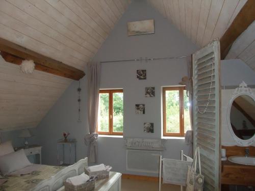 a room with a bed and a sink and a mirror at La Maison Du L.A.C. in Simard