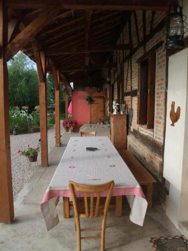 une table et deux chaises assises sous un bâtiment dans l'établissement La Maison Du L.A.C., à Simard
