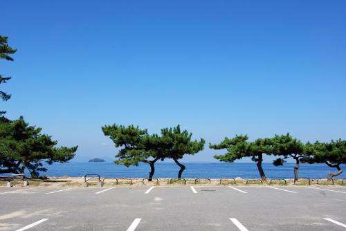 a parking lot with trees in front of the water at Jakomaru Park Tsuda in Sanuki