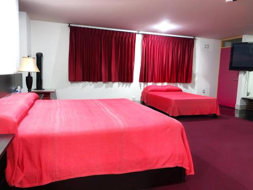 2 camas rojas en una habitación con cortinas rojas en Palacio Rojo Hotel Familiar, en Morelia