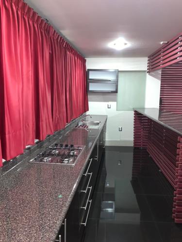 cocina con cortina roja y encimera en Palacio Rojo Hotel Familiar en Morelia