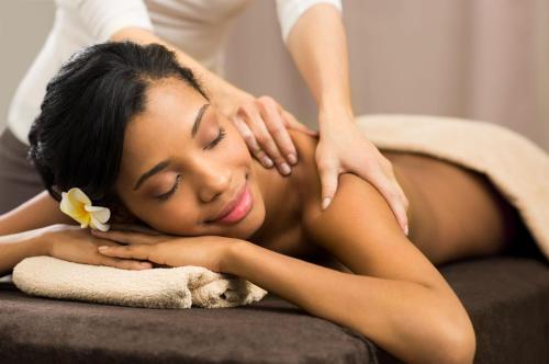a woman laying on a couch receiving aorative massage at Premier Hotel East London ICC in East London