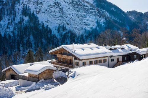 a house covered in snow in the mountains at Berg'k'hof Kaisertal - Alpine Hideaway in Ebbs