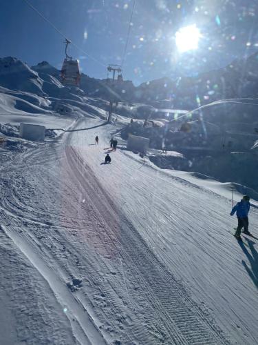 a group of people skiing down a snow covered slope at Suite il sogno di Grebek in Passo del Tonale