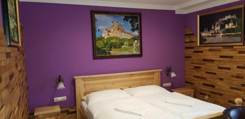 a bedroom with a bed with a purple wall at Gasthof Kaiser in Ybbs an der Donau