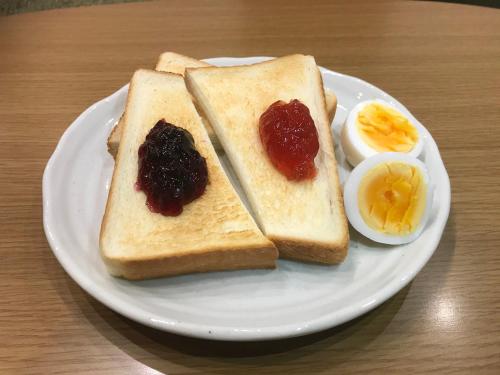 a white plate with two slices of toast and an egg at Guesthouse Nibutani Yanto in Biratori