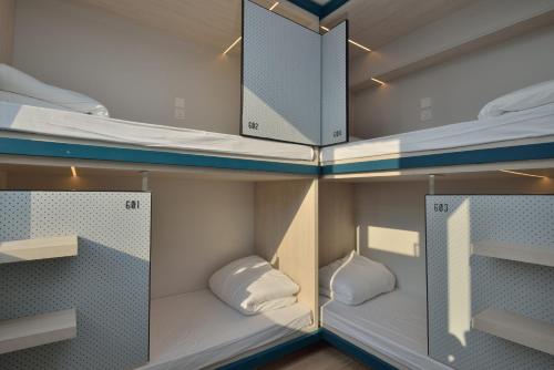 a room with three bunk beds in it at Atlas Hostel & Backpackers in Hong Kong