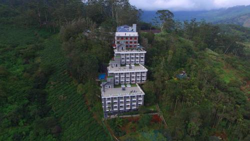 a large building on the side of a hill at Chandys Windy Woods Munnar in Munnar