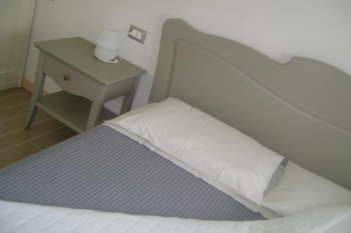 a bed in a room with a nightstand and a bed sidx sidx at Affittacamere Rubino Guest House in Ponte nellʼAlpi