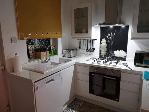 a kitchen with a sink and a stove top oven at Corner House, Sleeps 8 in 4 Bedrooms, near train station, Great Value! in Manchester
