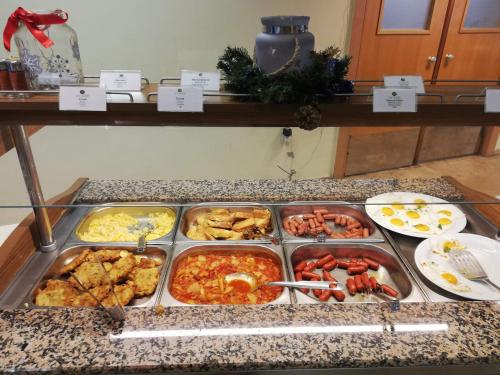 um buffet cheio de diferentes tipos de alimentos em um balcão em Sweet&Center Wellness apartman em Siófok