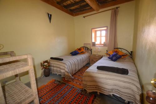 a bedroom with two beds and a window at Tizourgane Kasbah in Tiguissas
