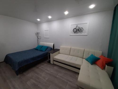 サラトフにあるДороти - уютная квартира на Степана Разинаのベッドルーム1室(ベッド1台、ソファ1台付)、壁に自転車が備わります。