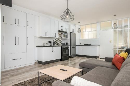 a living room with a couch and a kitchen at 116 Illovo Mews Studio in Johannesburg