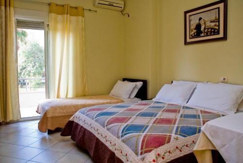 a bedroom with two beds and a window at Hotel 4 Stinet in Vlorë