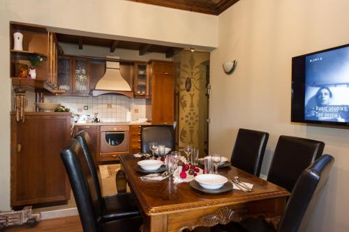 a dining room table with black chairs and a television at Petra Thea Villa Karitaina in Karítaina