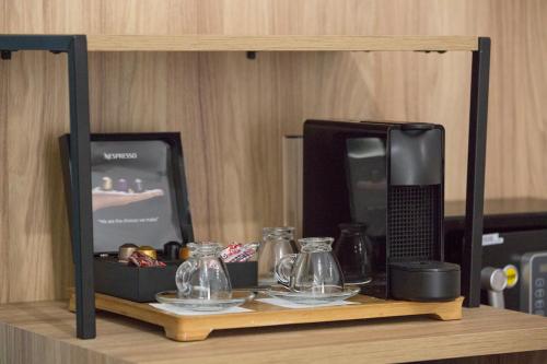 a shelf with a microwave and glass items on it at Alexandros in Giannitsa