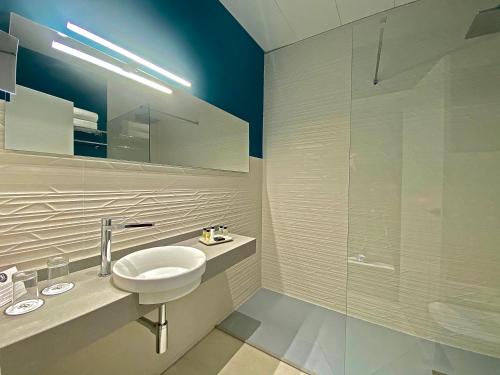 a bathroom with a sink and a glass shower at Soho Boutique Sevilla in Seville