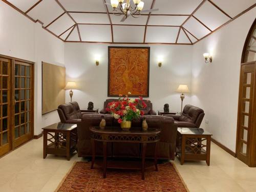 a living room with a couch and a table with flowers at Wild Mahseer in Tezpur
