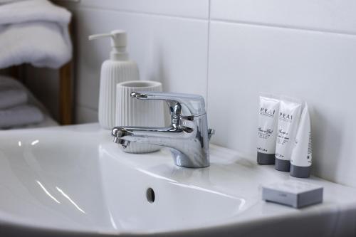 a bathroom sink with a faucet and toothbrushes at Cedro Apartment - Smart Holiday in Mantova