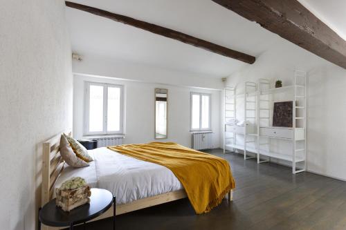 a white bedroom with a large bed with a yellow blanket at Cedro Apartment - Smart Holiday in Mantova