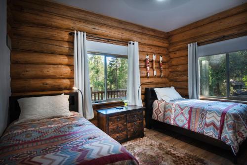 um quarto com paredes de madeira, uma cama e janelas em 38 The Mini Cabin em Wawona
