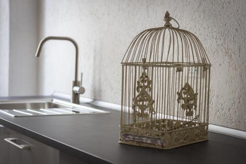 a bird cage sitting on a counter next to a sink at Cedro Apartment - Smart Holiday in Mantova