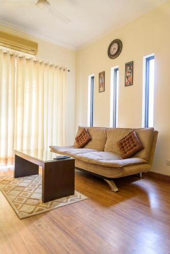 a living room with a couch and a table at Beautiful Apartments at Tarudhan Valley Golf Resort, Manesar in Gurgaon