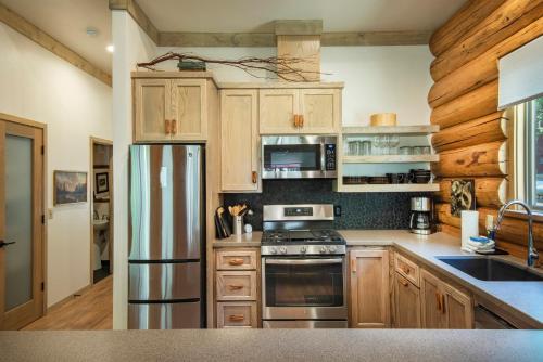 a kitchen with wooden cabinets and a stainless steel refrigerator at 38 The Mini Cabin in Wawona