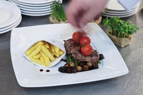 a plate of food with a steak and french fries at Mercure Czestochowa Centrum in Częstochowa