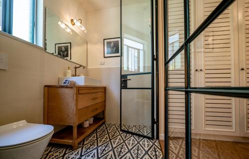 a bathroom with a toilet and a glass shower at VELLER Olifant in Tel Aviv