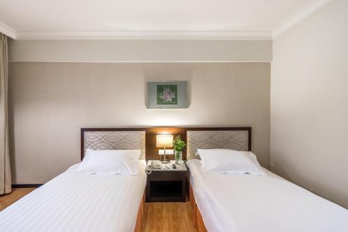 dos camas sentadas una al lado de la otra en una habitación en Crystal Crown Hotel Kuala Lumpur, en Kuala Lumpur