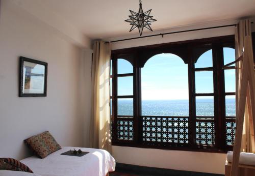 a room with a bed and a window with a view at Hashpoint Surf Camp in Taghazout