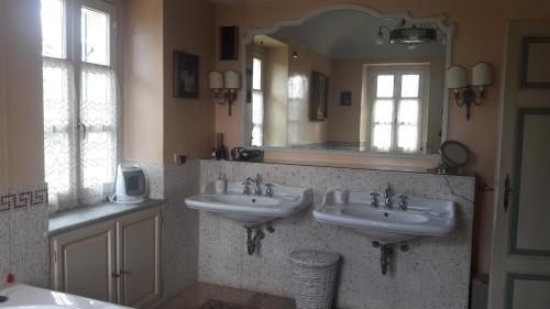 La salle de bains est pourvue de 2 lavabos et d'un grand miroir. dans l'établissement Villa Mirano Bed & Breakfast, à Piossasco