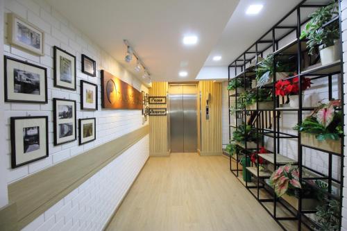 a hallway with a door and plants on the walls at OYO 482 Pannee Lodge Khaosan - SHA Plus in Bangkok