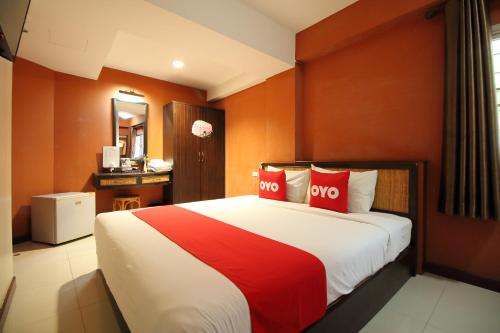 a bedroom with a large bed with two red pillows at OYO 482 Pannee Lodge Khaosan - SHA Plus in Bangkok
