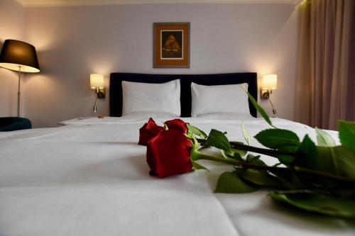 a bedroom with a white bed with a red rose on it at Art 'Otel in Sofia