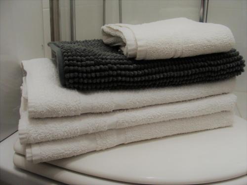 - une pile de serviettes assises au-dessus des toilettes dans l'établissement Apart BLANCO para ESQUÍ y ALHAMBRA. Garaje privado, à Grenade