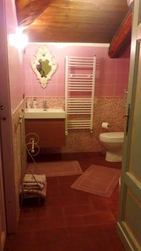 a pink bathroom with a sink and a toilet at Villa Mirano Bed & Breakfast in Piossasco