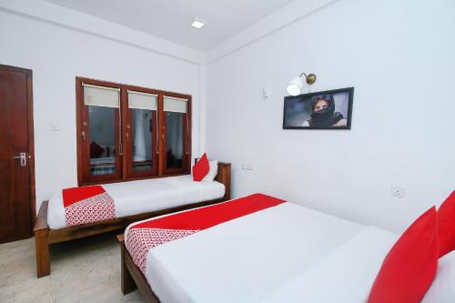 - une chambre avec 2 lits et une photo sur le mur dans l'établissement Lucas, à Bentota